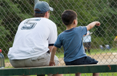 father and son watching baseball game